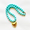 collana oversize con cuore grande dorato e perle celesti
