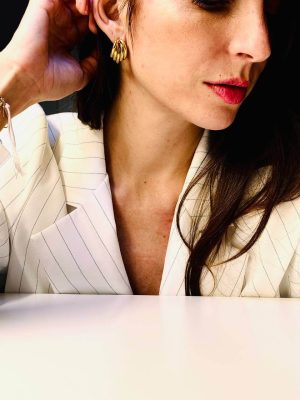 foto ragazza con capelli lunghi castani che indosSA ORECCHINI dorati in acciaio big eyes creations