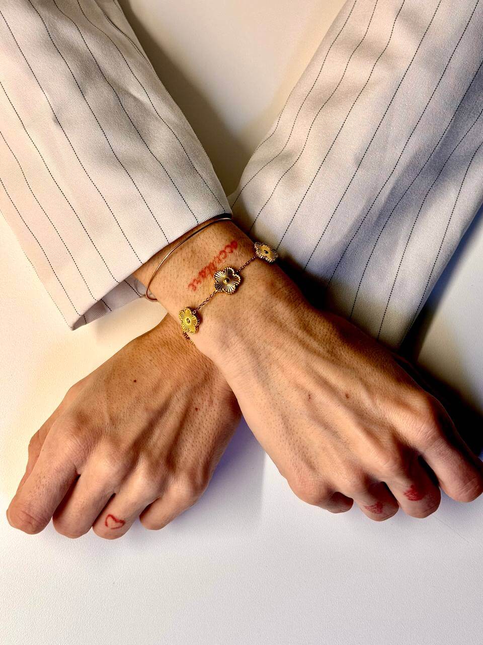 immagine di mani femminili incrociate con braccialetto dorato