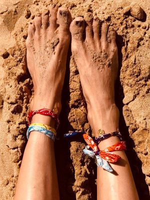 foto di piedi di ragazza sulla sabbia con cavigliere colorate big eyes creations