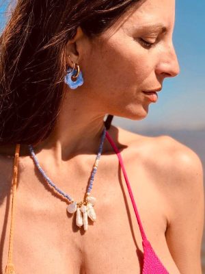 foto di ragazza in costume con collana di perline colorate e charms e orecchini blu big eyes creations