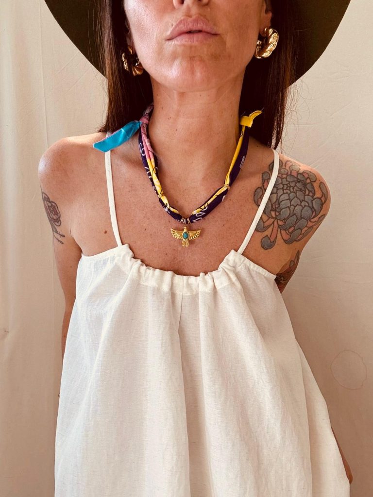 foto ragazza con cappello vestito estivo bianco e collana artigianale ibiza big eyes creations